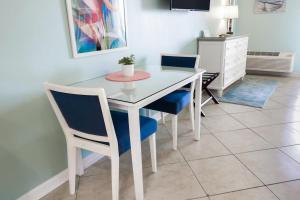 a dining room table with two chairs and a white table at Bright and Beautiful Dunes Room 2nd Floor in Pawleys Island +3 photos