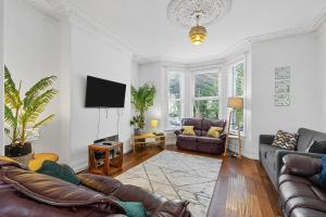 a living room with leather furniture and a flat screen tv at 4 Bed Park View House-Free Parking - Sleep 8 in Plymouth