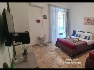 a bedroom with a bed and a desk and a television at Casa vacanze Andry in Cinisi