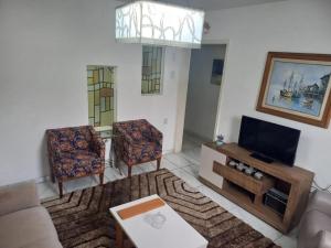 a living room with a couch and a tv at Apartamento Indianópolis in Caruaru