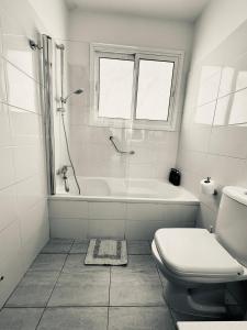 a white bathroom with a tub and a toilet at Serene Getaway Near Protaras in Paralimni +28 photos