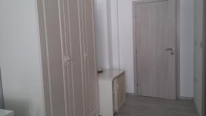 a white room with a door and a table and a cabinet at Brilliant Camere in Trieste