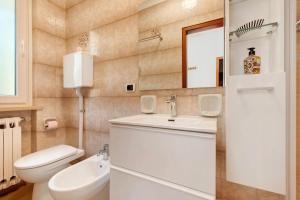 a bathroom with a white sink and a toilet at Casa Edda in Brenzone sul Garda +17 photos