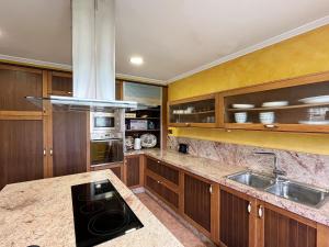a kitchen with wooden cabinets and a sink at Casa María B - a 3km del Camino in Santa Eulalia