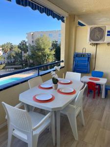 a white table and chairs on a balcony with a pool at PUNTA PRIMA y VISTAS PISCINA in La Pineda