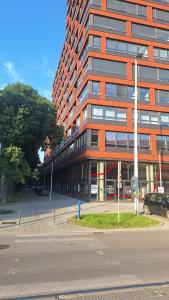 a tall orange building with a car parked in front of it at Lux Mila with Free Private parking in Novi Sad