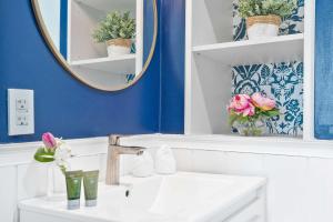 a bathroom with a sink and a mirror and flowers at MVR - Your Private Slice of Grove Luxury Awaits in Miami