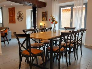 a dining room with a wooden table and chairs at Chambres "Chez ELLE" in Oraison