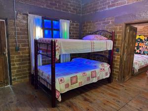 two bunk beds in a room with a brick wall at Román Cabañas del Mirador 4 in Pahuatlán del Valle