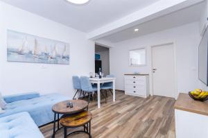 een witte woonkamer met een bank en een tafel bij House Herta in Gdinj