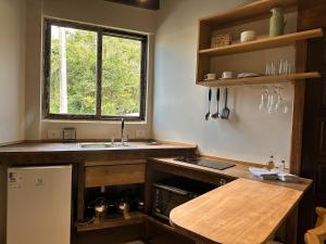 een keuken met een aanrecht, een wastafel en een raam bij Refúgio perto do mar em Mariscal 02 in Bombinhas +22 foto's