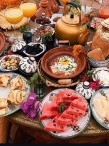 a table filled with plates of food and drinks at Family Berber Camp in Merzouga