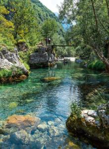 a river with a bridge over it in the mountains at Guesthouse Te Tata in Theth