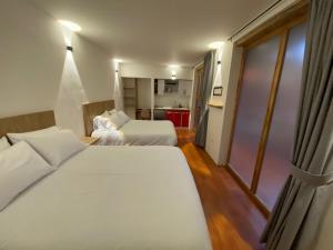 a hotel room with two beds and a kitchen at Apartaestudio comodo y central S2 - WiFi in Pasto