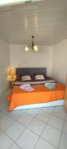 a bedroom with a large bed with an orange blanket at Casa do Carvoeiro in Fundão