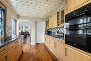 a large kitchen with wooden cabinets and black appliances at 4 Bed Park View House-Free Parking - Sleep 8 in Plymouth