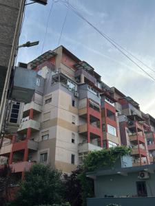 an apartment building with red and white at Rajs Apartment in Tirana