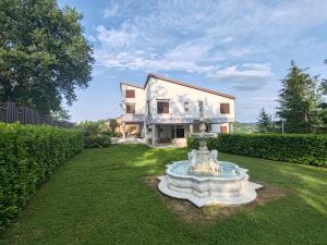 a house with a fountain in the yard at Villa Andreina in Amandola