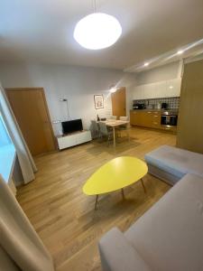 un salon avec une table jaune et un canapé dans l'établissement Vilnius Central Living – Jakšto place, à Vilnius