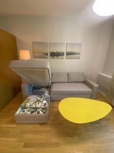 - un salon avec un canapé et une table jaune dans l'établissement Vilnius Central Living – Jakšto place, à Vilnius