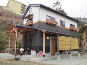 a house with a balcony on top of it at Villa Orange Cabin in Fujikawaguchiko