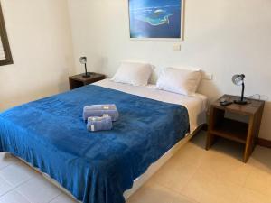 a bedroom with a large bed with a blue blanket at Beach Front 2 Bed Rooms - Balcony with Full Sea View - Praia do Pepê in Rio de Janeiro