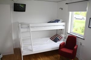 a white bunk bed in a room with a red chair at Uncle Joe's in Visby