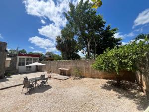 a patio with a table and chairs and an umbrella at Casa G&G in Valladolid