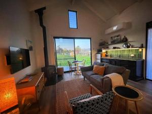 a living room with a couch and a table at Lume King Valley in Whitfield