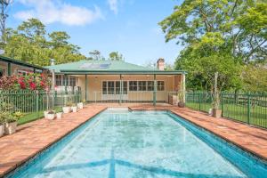 a swimming pool in front of a house at Historic Huntingdon House in Wauchope