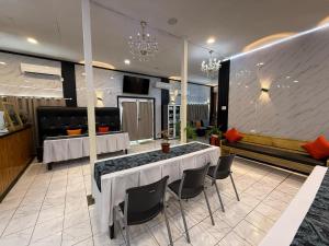 a restaurant with a table and chairs in a room at Moatoga Hotel in Apia