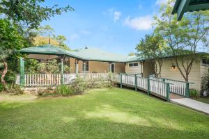 a house with a fence and a yard at Historic Huntingdon House in Wauchope
