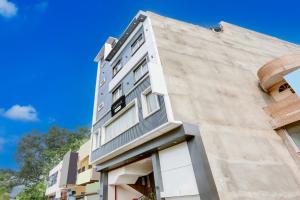 a tall building with white windows on the side of it at Super Townhouse Model Town Rohtak Formerly Hotel Tathastu in Rohtak