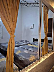 Dos camas individuales en una habitación con ventana. en Finca Campestre Villa Bernati, en Villavicencio