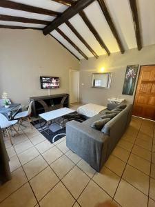 ein Wohnzimmer mit Sofa und Tisch in der Unterkunft Exquisite cottage in Doringkloof in Centurion