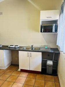 eine Küche mit Spüle und Theke in der Unterkunft Exquisite cottage in Doringkloof in Centurion