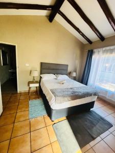 ein Schlafzimmer mit einem großen Bett in einem Zimmer in der Unterkunft Exquisite cottage in Doringkloof in Centurion