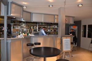 un bar con dos personas parados en un mostrador en Le Miracle, en Lédenon