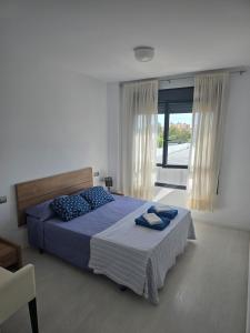 Un dormitorio con una cama y una ventana grande. en Piscina y Pádel al lado del Mar, en Torredembarra 20 fotos más