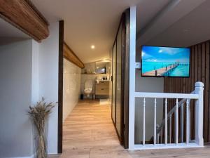 a hallway with a staircase with a television on a wall at Studio au bord du canal du midi in Carcassonne