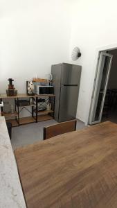 Una cocina con refrigerador y una mesa con sillas. en Foresteria del Genio - Luxury Suites & Urban Spa, en Palermo