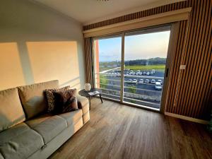 蓬塔德尔加达Paim Lodge的带沙发和大窗户的客厅