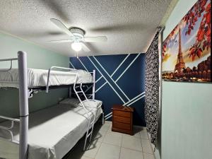 une chambre avec des lits superposés et une fresque de la tour Eiffel dans l'établissement Sensity home C Escolar Departamento hogareño y Calido para familias, à Tehuacán