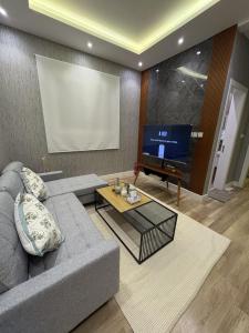 リヤドにあるغرفة وصالة فندقية حي حطينのソファと大型テレビのあるリビングルーム