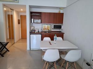 a kitchen with a white table and white chairs at Concord Pilar Suite Almendros in Pilar