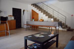 a living room with a table and a staircase at Casas Ti Flores in Sabugal