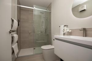 a bathroom with a shower and a toilet and a sink at Taradale Gem in Napier +14 photos