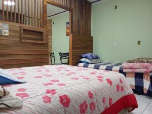 a bedroom with two beds with red flowers at Hospedagem Ribeiro in Urubici