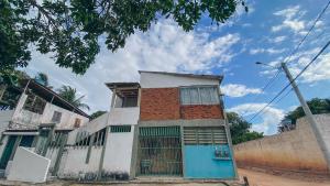 a building with a blue door on a street at Privê Coqueiral in São José da Coroa Grande