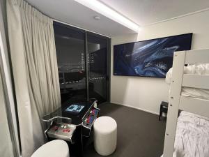 1 dormitorio con 1 cama y 1 habitación con TV en Arcade In The Sky- Views Games & Vibes, en Brisbane